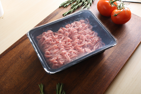 minced meat in packing on a wooden backgroundの写真素材