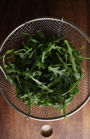 washed arugula on a wooden backgroundの写真素材