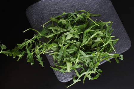 arugula on a dark stone backgroundの写真素材