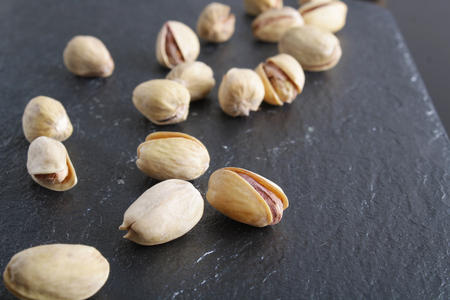 pistachios on a dark stone backgroundの写真素材