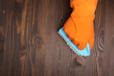 orange glove and brush on a wooden background