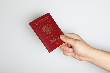 Passport in hand on a light backgroundの写真素材