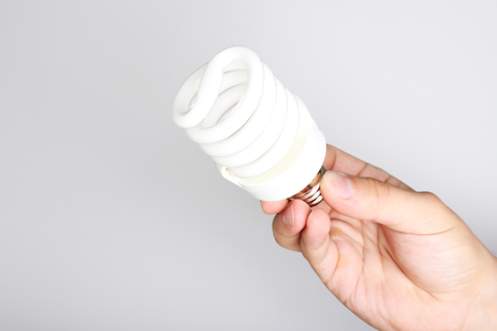 energy saving light bulb in hand on a light background