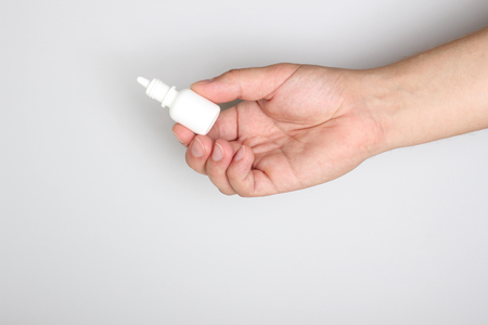 drops for the eyes in the hand on a light backgroundの写真素材