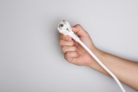 electric plug in hand on a light background