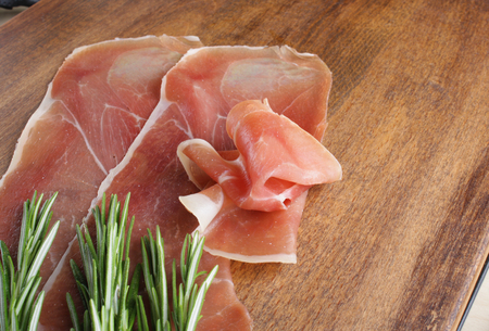 prosciutto jamon ham on a wooden background rosemaryの写真素材