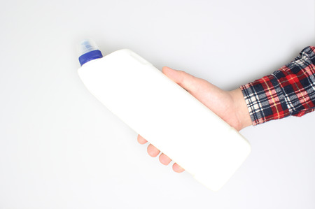 white detergent bottle in hand