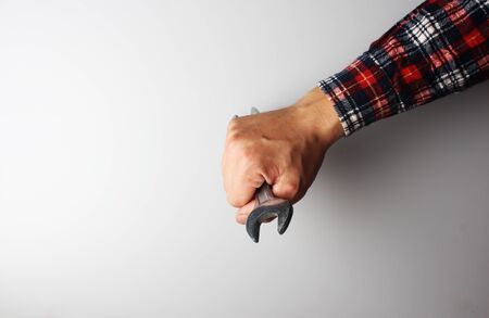 wrench in hand on a gray backgroundの写真素材