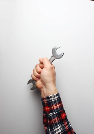 wrench in hand on a gray backgroundの写真素材