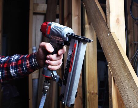 pneumatic stapler red hand wooden workerの写真素材