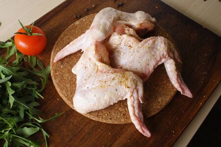 chicken wings fresh on a wooden backgroundの写真素材