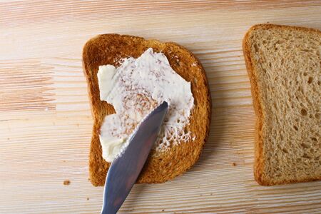 toast with butter on a wooden backgroundの写真素材