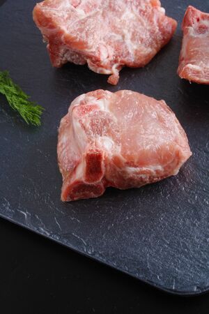 pieces of meat bone on a dark stone backgroundの写真素材