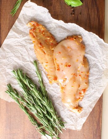 chicken breast in marinade spice, board, rosemaryの写真素材