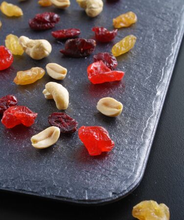 nuts dried fruits on a dark stone backgroundの写真素材