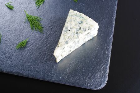 blue cheese on a dark stone backgroundの写真素材