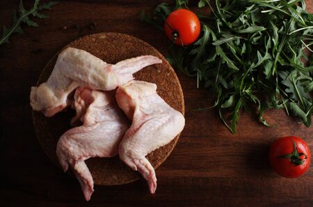 chicken wings fresh on a wooden backgroundの写真素材