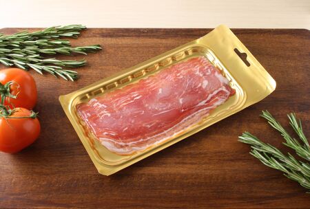 bacon in packing on a wooden backgroundの写真素材