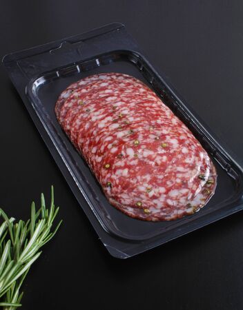 sausage sliced in a package on a black backgroundの写真素材
