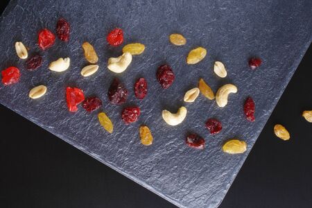 nuts dried fruits on a dark stone backgroundの写真素材