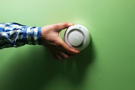 fire alarm sensor hand on a green background