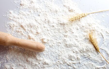 flour of a rolling ears spikelets of wheat on a light background