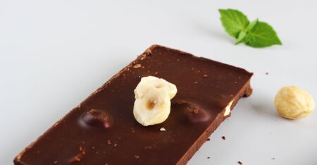 chocolate bar with hazelnut on a light backgroundの写真素材