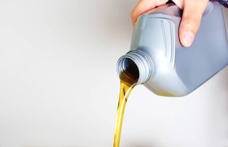 automotive oil in a hand a gray bottle on a light backgroundの写真素材