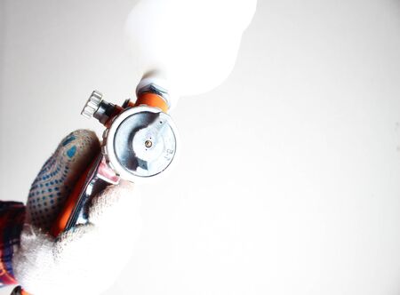 orange airbrush hand in glove on a light backgroundの写真素材