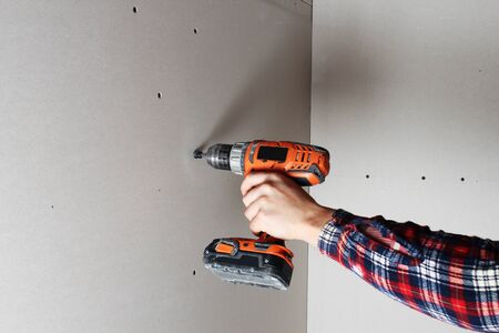 mounting drywall screwdriver hand in gloveの写真素材