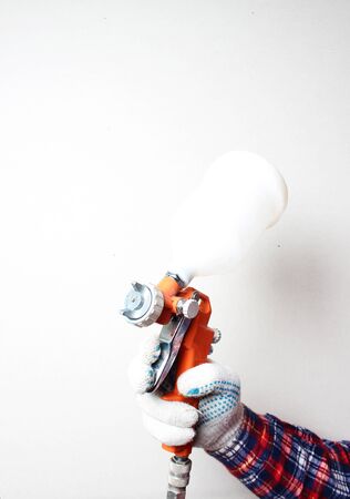 orange airbrush hand in glove on a light backgroundの写真素材
