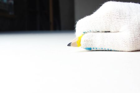 building yellow pencil in hand construction gloveの写真素材