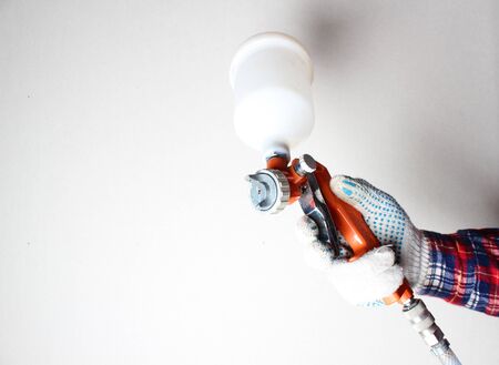 orange airbrush hand in glove on a light backgroundの写真素材