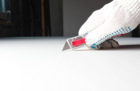 drywall construction knife in hand red bladeの写真素材