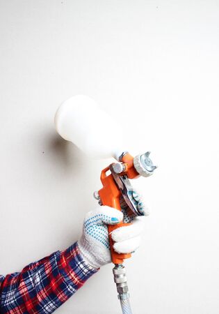 orange airbrush hand in glove on a light backgroundの写真素材