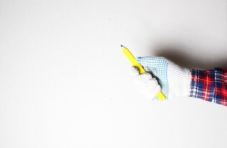 building yellow pencil in hand construction gloveの写真素材