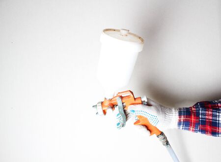 orange airbrush hand in glove on a light backgroundの写真素材
