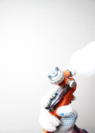orange airbrush hand in glove on a light backgroundの写真素材