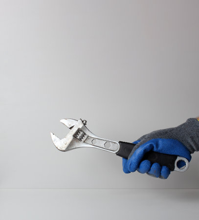 wrench hand in blue gloveの写真素材