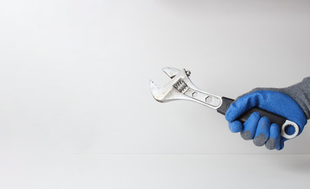 wrench hand in blue gloveの写真素材