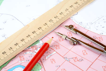 Red pencil  compasses and  ruler on a topographic map