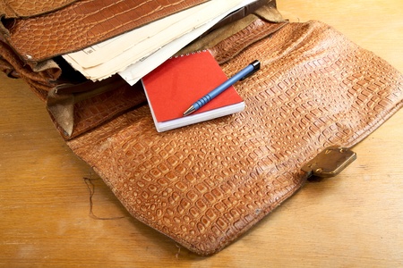 Old portfolio from a crocodile leather on  desk