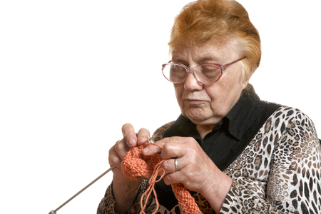 The grandmother knits spokes isolated on a white backgroundの写真素材