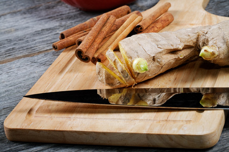 Kitchen knife ginger cinnamon on a chopping boardの写真素材