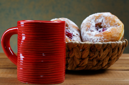 Red cup and fruitcakes in plates on a rural tableの写真素材