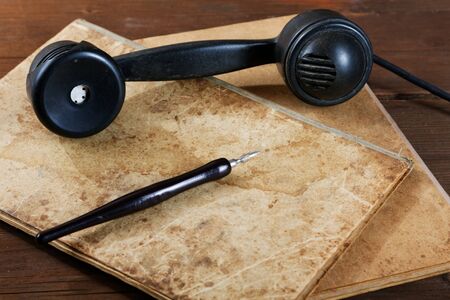 Still-life with old writing-books a nib and phone