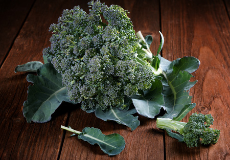head of broccoli with leaves in a tableの写真素材