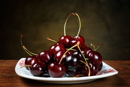 Cherry in a plate on a rural tableの写真素材