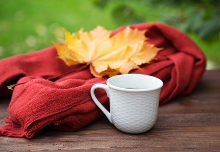 cup of tea on the table with a scarf and a pile of booksの写真素材