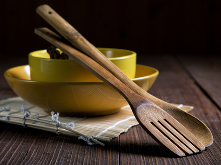 still life with plates and spatulas for food on an old tableの写真素材